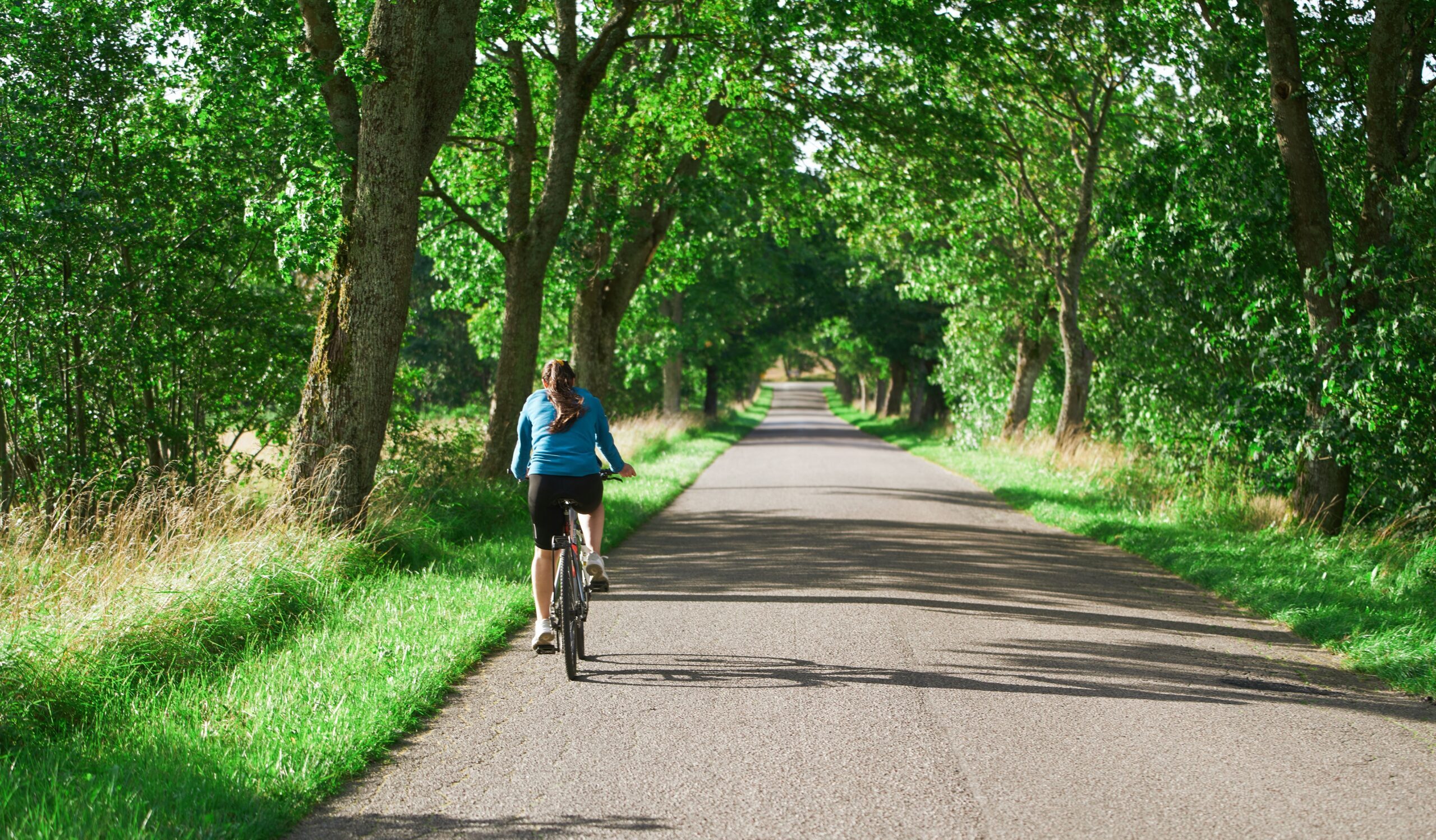 Woman riding bike in countryside sunny day